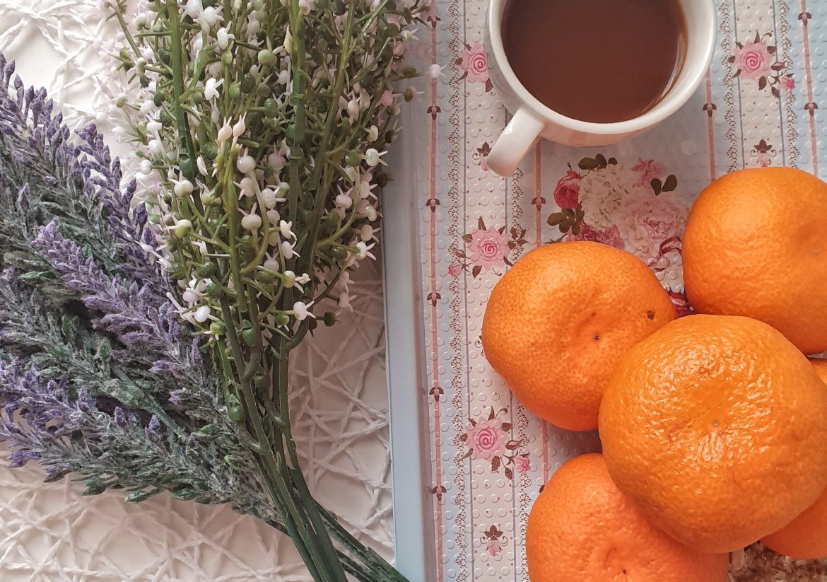 Coffee with pretty flowers and oranges to showcase its health benefits